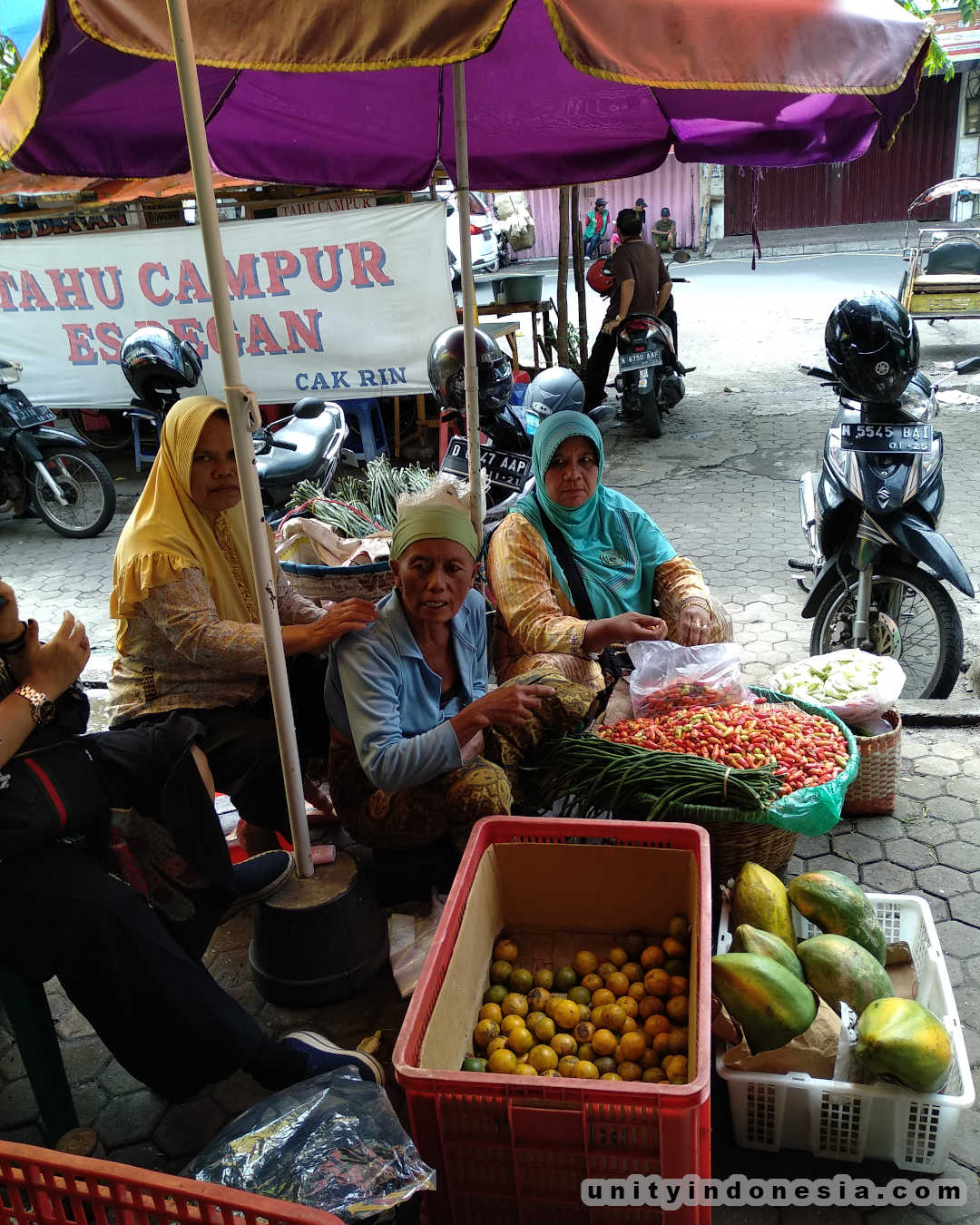 Women selling fruit at a traditional market.